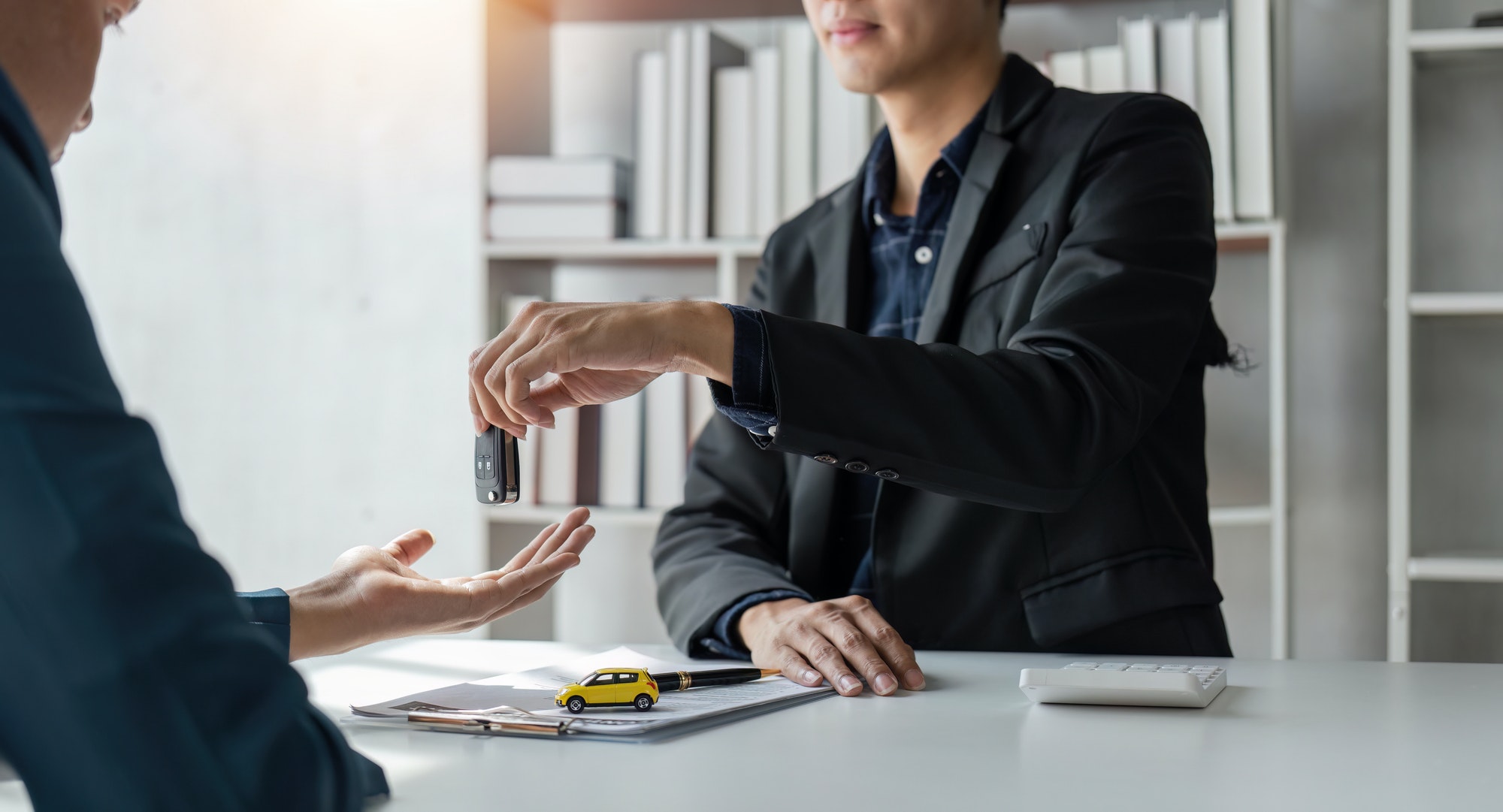 Loan approver, businessman giving car keys after car loan approval and contract signing